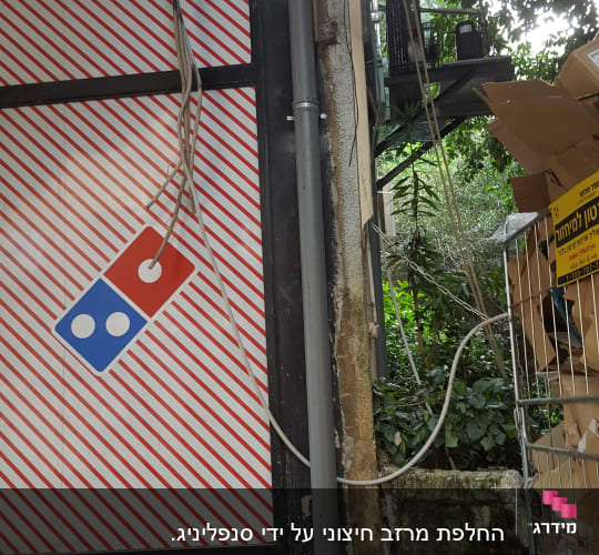 לוגו דומינוס על קיר עם צינורות וחוטים